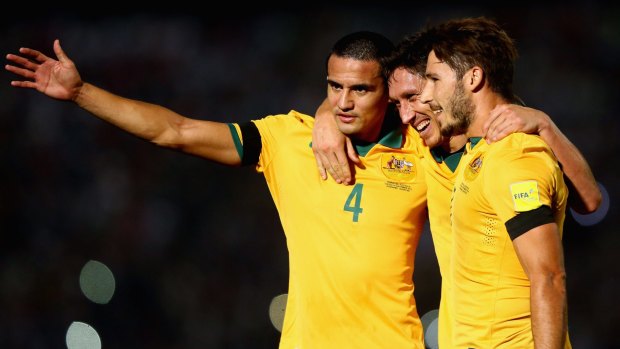 Mark Milligan (centre) celebrates with Mathew Leckie and Tim Cahill after Milligan scored their first goal in September's win over Tajikistan.