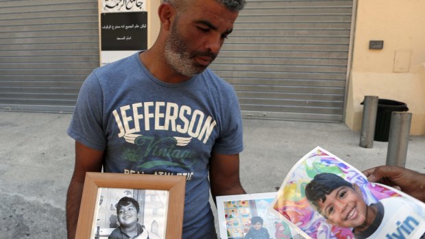 Tahar Mejri holds photographs of his 4-year-old son, Kylan.