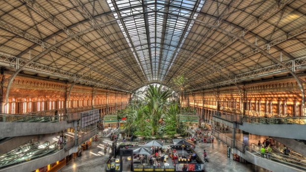 People sit in a cafe by the tropical garden at Madrid's Atocha station.