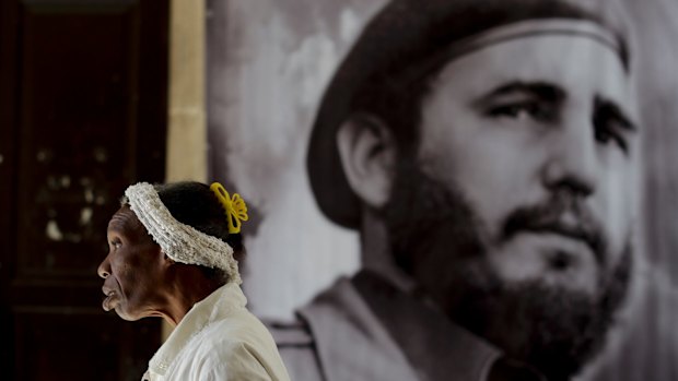 A woman walks past one of hundreds of tribute sites to Fidel Castro set up across Cuba.