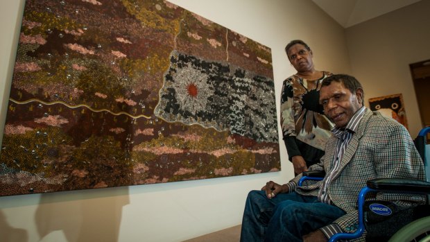 Artist Clifford Possum Tjapaltjarra's children Gabriella, from Melbourne, and Lionel Possum, from Alice Springs, see their father's work "Warlugulong" at the National Gallery of Australia.