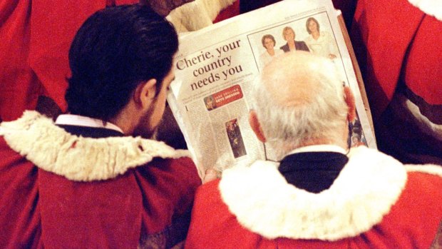 Members of the House of Lords read a newspaper article about Labour women MPs' fashion sense before the Queen delivers her speech in 1997.