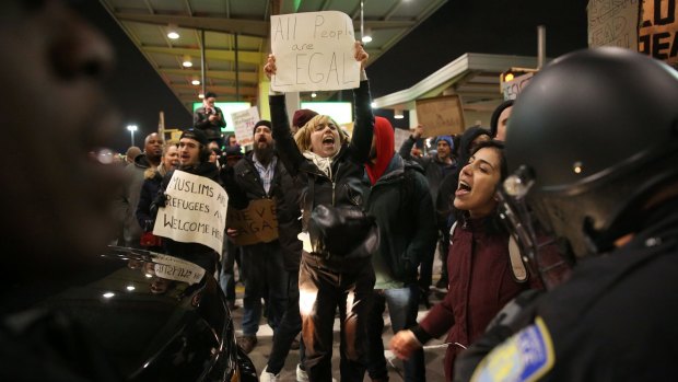 Police intervene and arrest some activists during the protest against President Donald Trump's 90-days ban at JFK airport in New York.