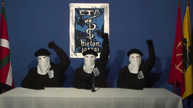 In this file image made from video provided in October, 2011, masked members of the Basque separatist group ETA raise their fists in unison following a news conference at an unknown location.