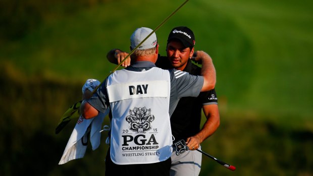 At last: Jason Day celebrates with his caddie Colin Swatton.