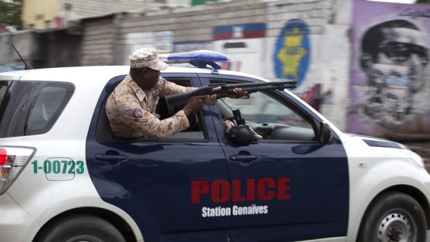 A police officer fires at demonstrators in Port-au-Prince.