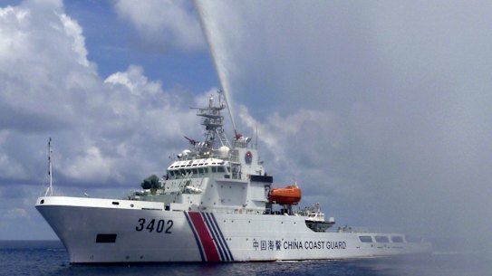 A Chinese Coast Guard boat sprays a water cannon at Filipino fishermen near Scarborough Shoal in the South China Sea last year.