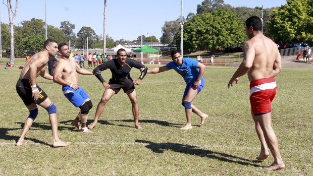 Men competing in India wrestling at World Refugee Day celebrations in Annerley.