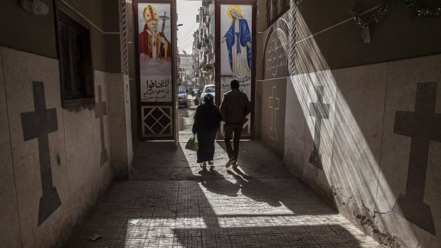 Coptic Christians walk outside St Mark's Church in Minya, south of Cairo. 