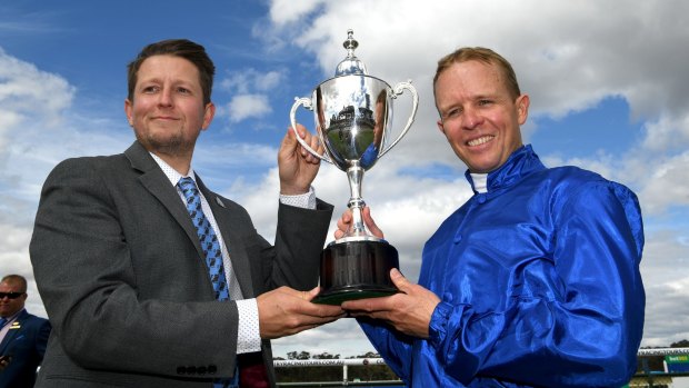 Jockey Kerrin McEvoy and travelling foreman Chris Connett with the Bendigo Cup after Qewy's win on Wednesday.