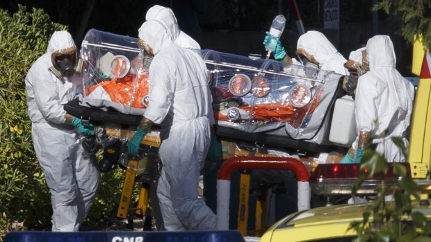 Infected: Health workers transfer Miguel Pajares, who has since died, in Madrid.