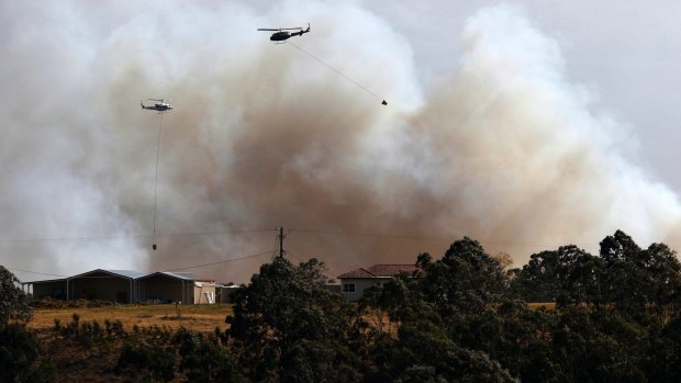 A water bombing helicopter fights the bushfire at Richmond Vale near Cessnock.
