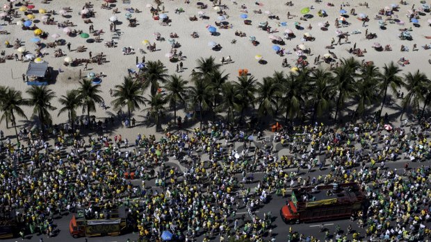 Sun-lovers in Copacabana are outnumbered by protesters on Sunday. 