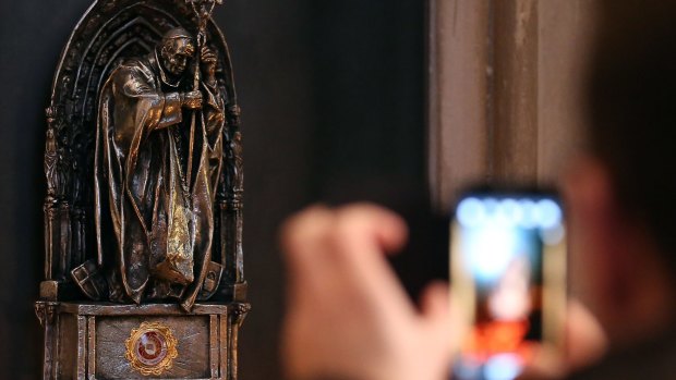A picture a tourist takes a picture of a religious relic of late Pope John Paul II   in the Cologne Cathedral. A cloth with a drop of blood from the late pope has been stolen from the cathedral.  