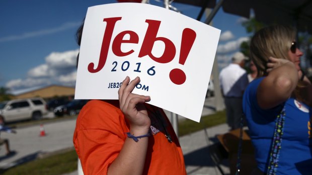 Jacob Parent, 14, of Punta Gorda, Florida, holds a Jeb Bush poster at a campaign rally.