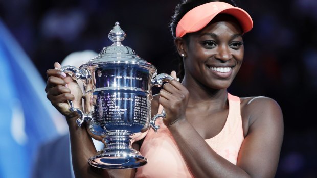 Sloane Stephens, of the United States, holds up the championship trophy after beating Madison Keys. 