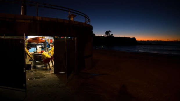 Members of the Coogee Surf Life Saving Club clear out their boatshed which was inundated with water and sand during the storms.