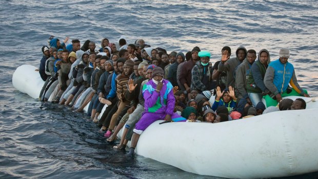 Migrants and refugees wait to be helped by members of the Spanish NGO Proactiva Open Arms, as they crowd aboard a rubber boat in the Mediterranean north of Sabratha, Libya last week.