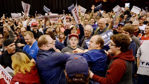 A protester scuffles with Donald Trump supporters at a rally for the Republican presidential candidate in Cleveland, Ohio on Saturday.