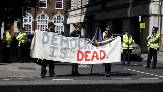 Protesters hold a banner during a protest in central London on Saturday.