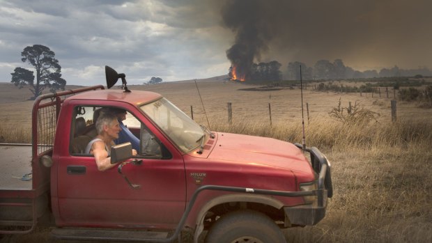A local watches the fire near Mount Bolton from his ute.