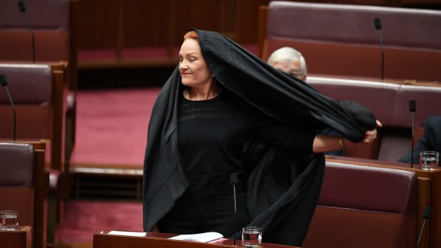 One Nation senator Pauline Hanson takes off the burqa. The stunt would likely not have been allowed under old Senate rules.