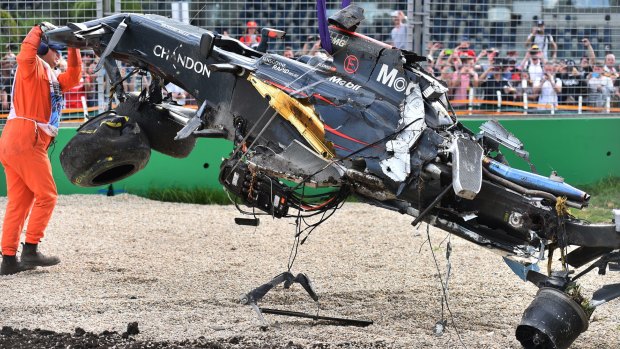 Scrap metal: a track official helps remove Fernando Alonso's McLaren after the crash