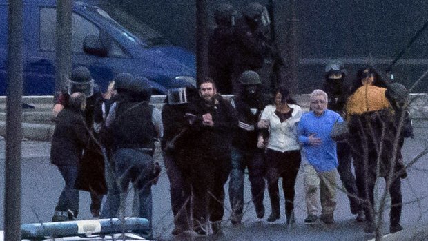 Security officers escort released hostages after they stormed a kosher grocery store.