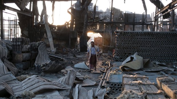 A man walks through the remains of a factory that was bombed twice in September outside of Yemen's capital Sanaa.