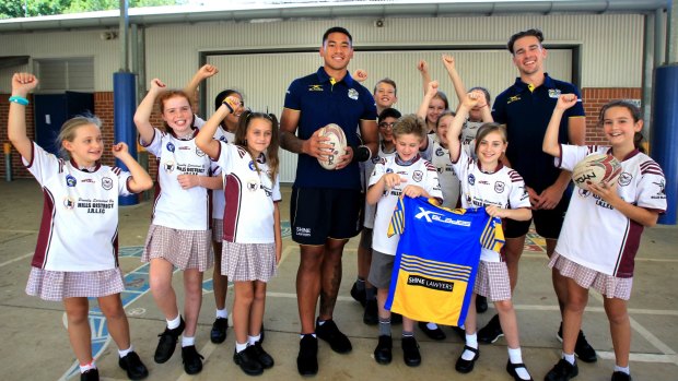 With the kid: John Folau (left) and Clint Gutherson (right) visit Crestwood Public School on Thursday. 