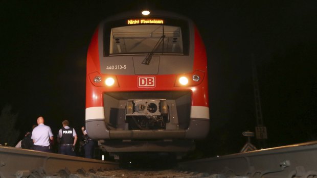 Police officers stand beside a train in Wurzburg, southern Germany, after a 17-year-old Afghan armed with an axe and a knife attacked passengers.