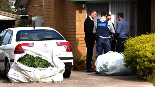 Police inspect bags, which were removed from a house at Brougham Avenue.