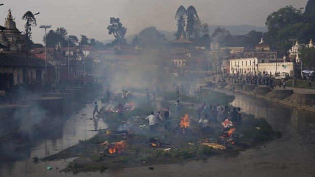Flames rise from burning funeral pyres during the cremation of victims of Saturday's earthquake, at the Pashupatinath temple on the banks of Bagmati river, in Kathmandu.