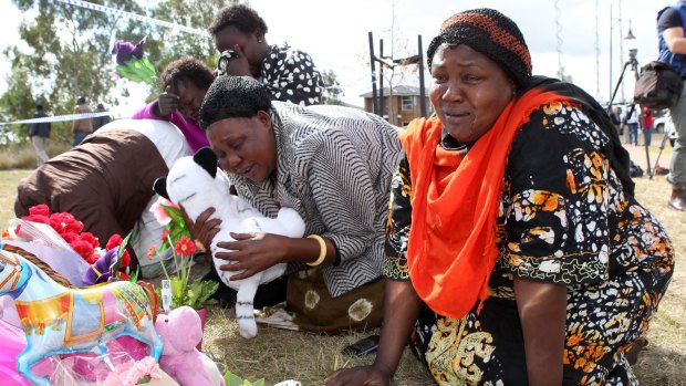 Members of the local Sudanese community grieve at the scene in Wyndham Vale.