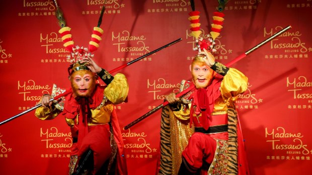 Chinese actor Zhang Jinlai in a Monkey King costume poses next to a wax figure base on his performance at Madame Tussauds in Beijing.