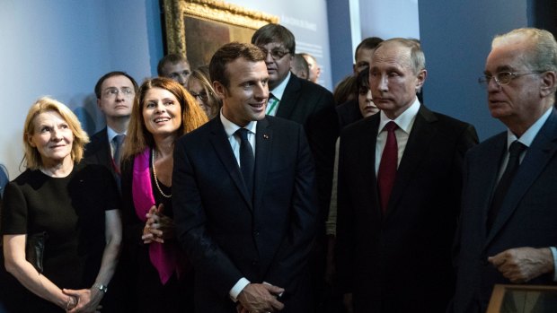 Emmanuel Macron, centre, and his Russian counterpart Vladimir Putin, 2nd right, visit an exhibition about Russian emperor Peter the Great at the Grand Trianon after their meeting.