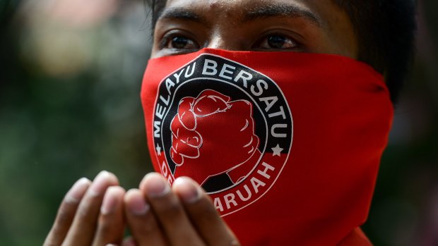 A pro-government 'red-shirt' protester with a face mask which reads "Malays United" in Kuala Lumpur.