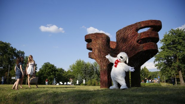 A person dressed as a dog entertains visitors at the Hugs artwork created by Belorussian designers Vasily Timashov and Polina Pirogova at the Art Islands exhibition in Minsk, Belarus on June 23, 2016.