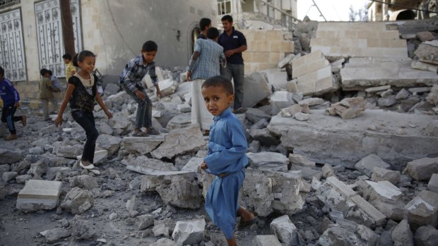 Children walk over the rubble of a house destroyed by an air strike by the Saudi-led coalition on the Yemeni capital, Sanaa.