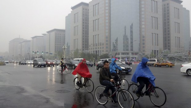 Residents ride their bicycles  along Chang'an Avenue on a hazy day in central Beijing in March.