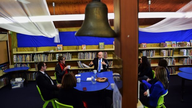 Education Minister Adrian Piccoli speaks to the principal and teachers at Villawood North Public School amid concerns about Gonski funding. 
