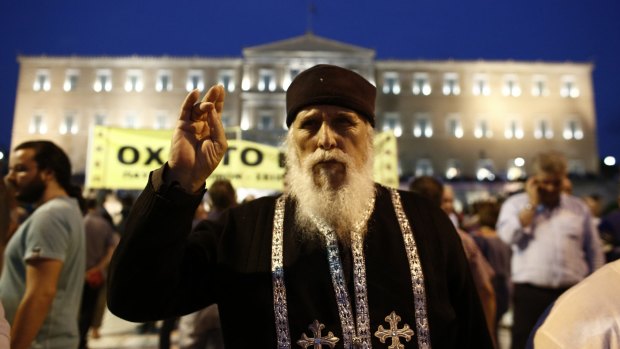 A Greek orthodox priest takes part in a rally at Syntagma square in front of the Greek parliament on Sunday.