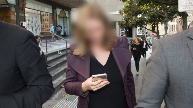 The woman, who cannot be identified, leaves the Downing Centre court complex on Thursday.