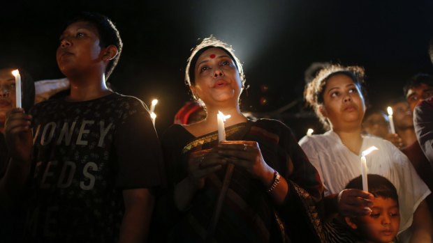 Bangladeshis light candles and sing songs as they pay tribute to those killed in the attack.