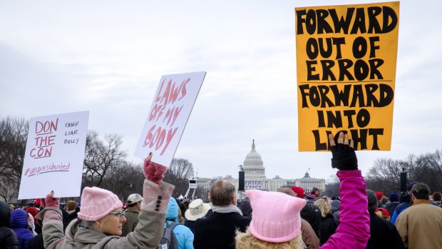 Protesters hold signs against US President Donald Trump at the National Mall during the  inauguration.
