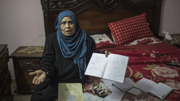 Amna Hassan, mother of Ishaq Khalil Hassan,  with photos and documents relating to her son.