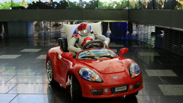 One of the NAO robots drives a small car at Queensland University of Technology.