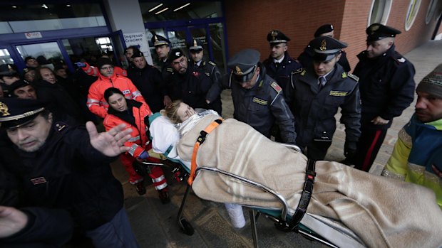 Medics transport a wounded woman from the "Spirit of Piraeus" cargo container ship as they arrive in Bari harbour.