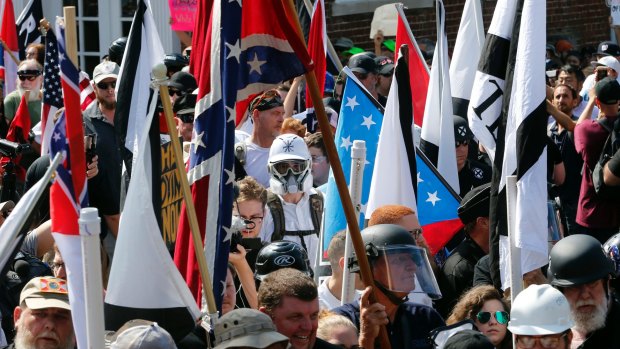 White nationalist demonstrators walk into the entrance of Lee Park surrounded by counter demonstrators in Charlottesville on Saturday.