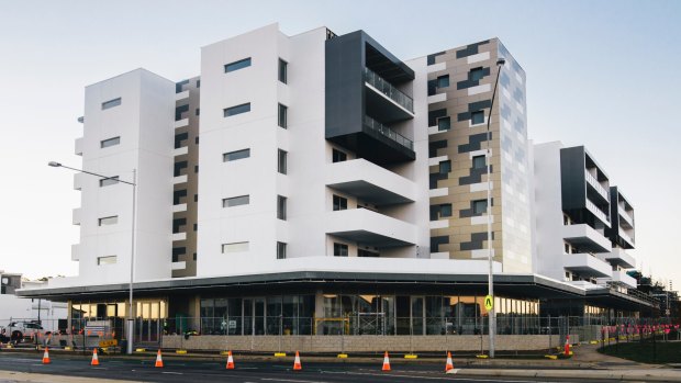 The Esque building on the corner of Flemington Road and Manning Clark Crescent in Franklin: The developers has offered to pay for electricity meters for apartment owners who can't get their chosen colour scheme.